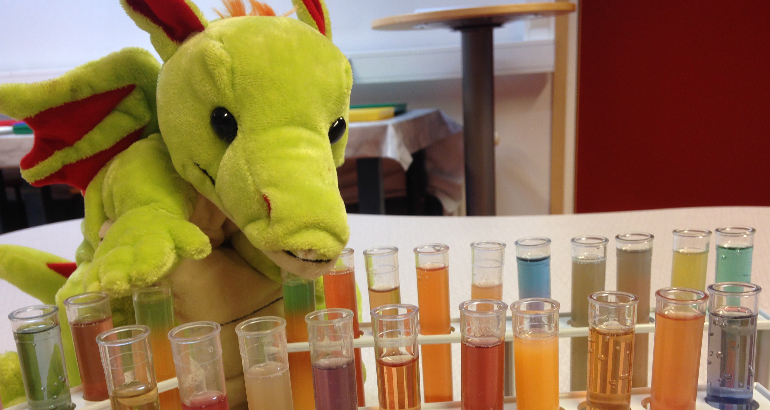 En grön låtsasdrake och många provrör